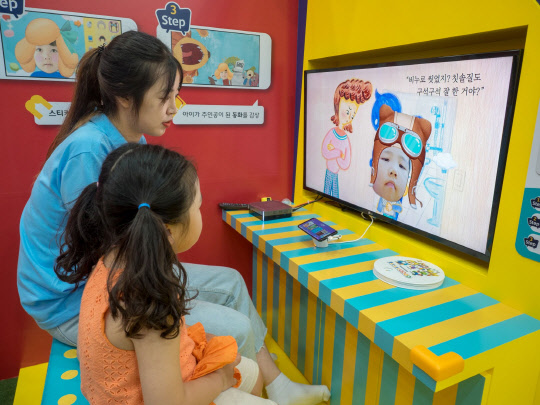 SK브로드밴드 모델이 B tv 키즈서비스 '살아있는 동화 2.0'을 시연하고 있다. SK브로드밴드 제공